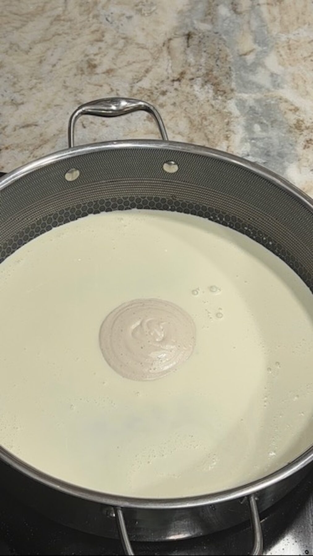 A pot with cream sauce in it for chicken bacon ranch tortellini.