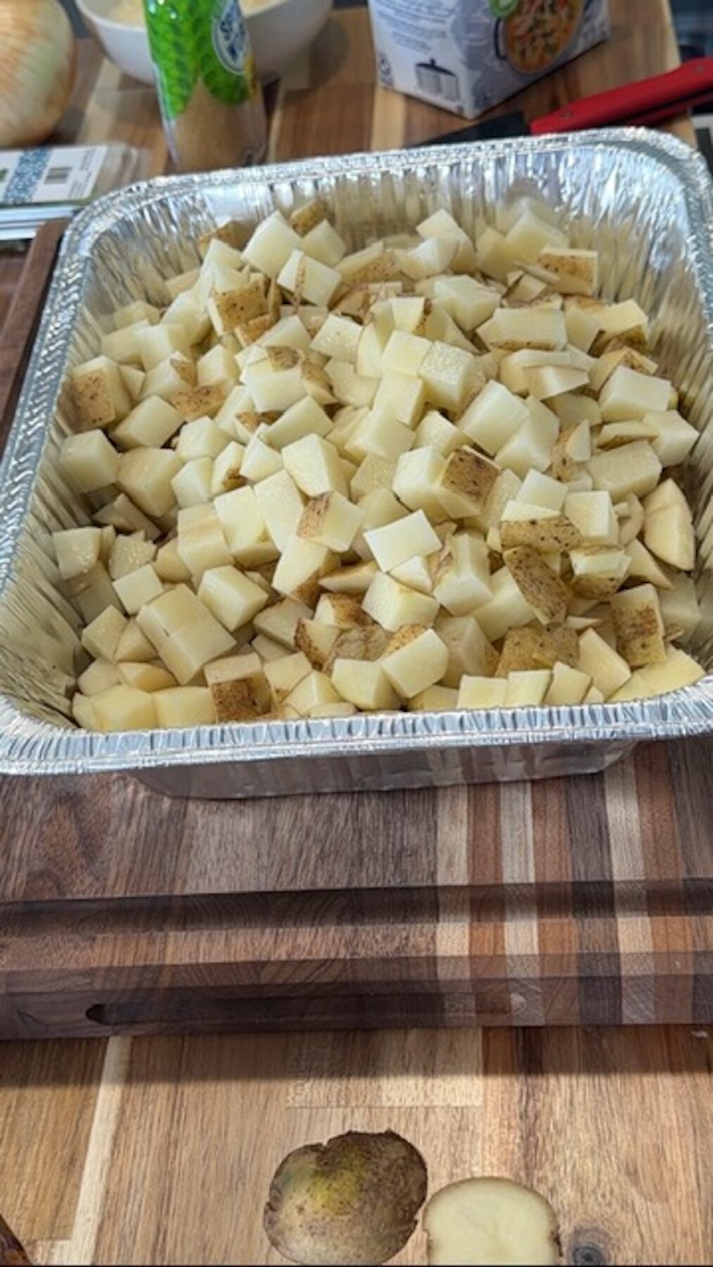 cubed potatoes in aluminum tray on cutting board