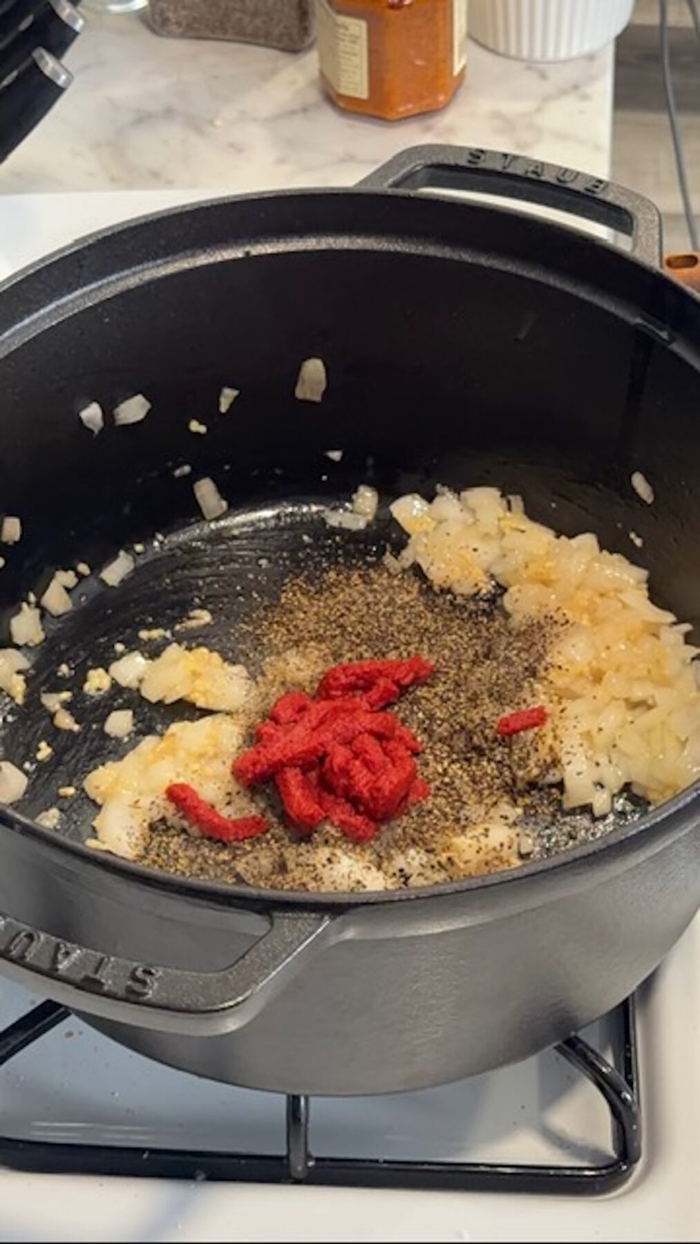 onions, spices and tomato paste in pot for marry me chicken potato soup