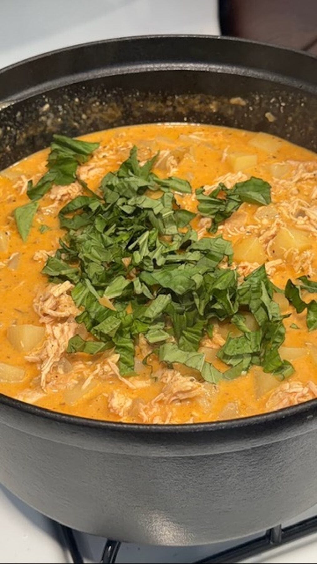marry me chicken potato soup in pot topped with fresh herbs