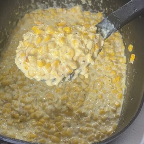 cooked slow cooker creamed corn with spoonful of creamed corn