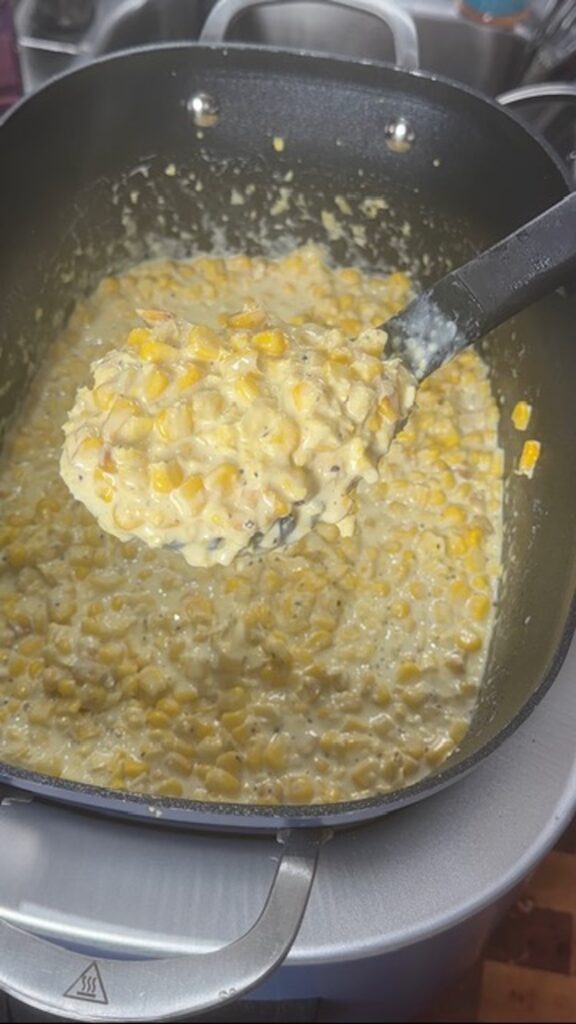 cooked slow cooker creamed corn with spoonful of creamed corn