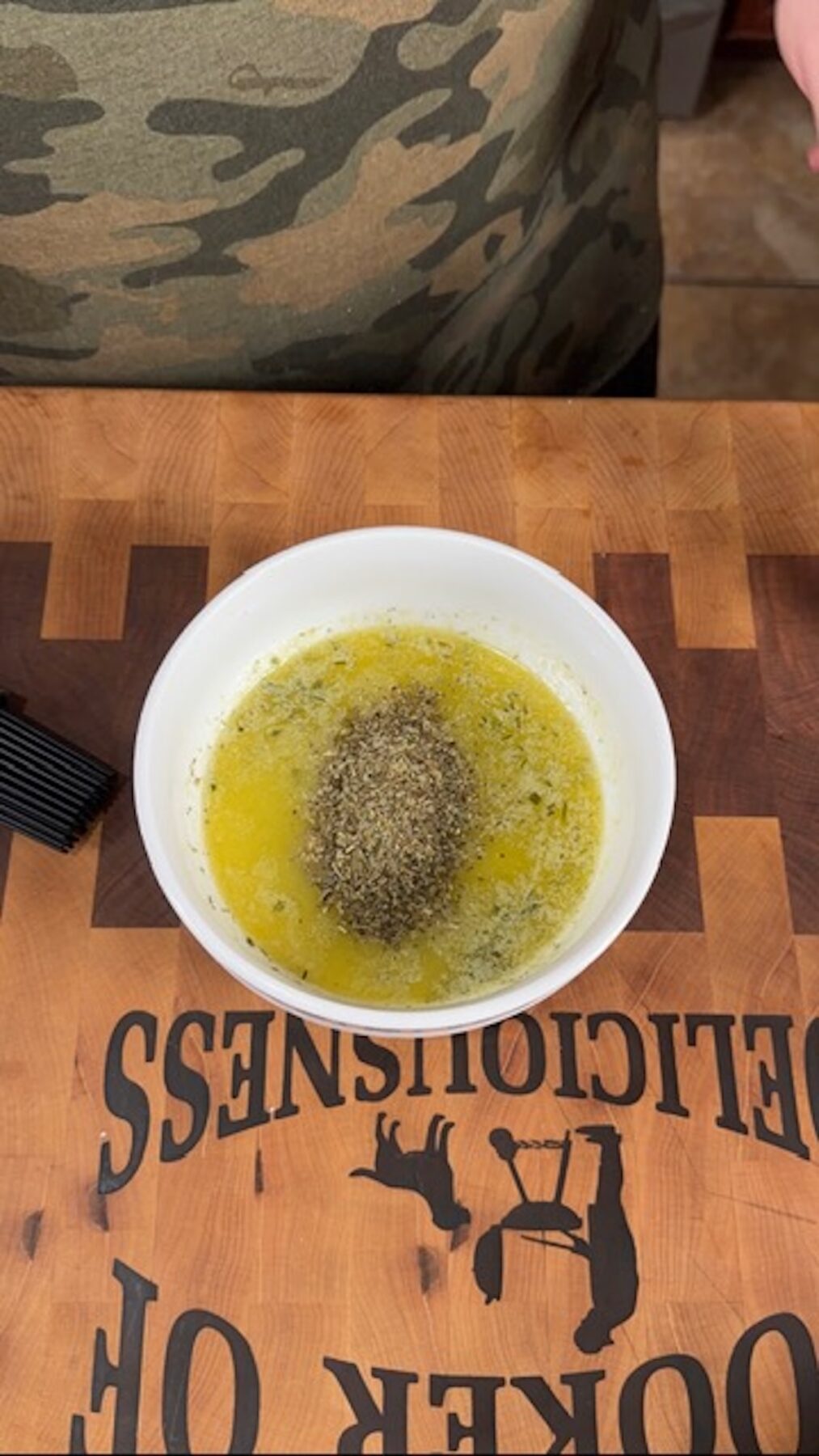 A white bowl with seasoned melted butter.