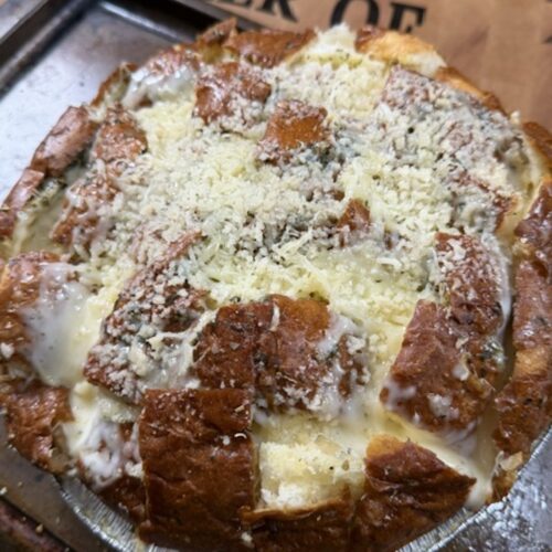 Close up of baked cheesy pull apart bread.