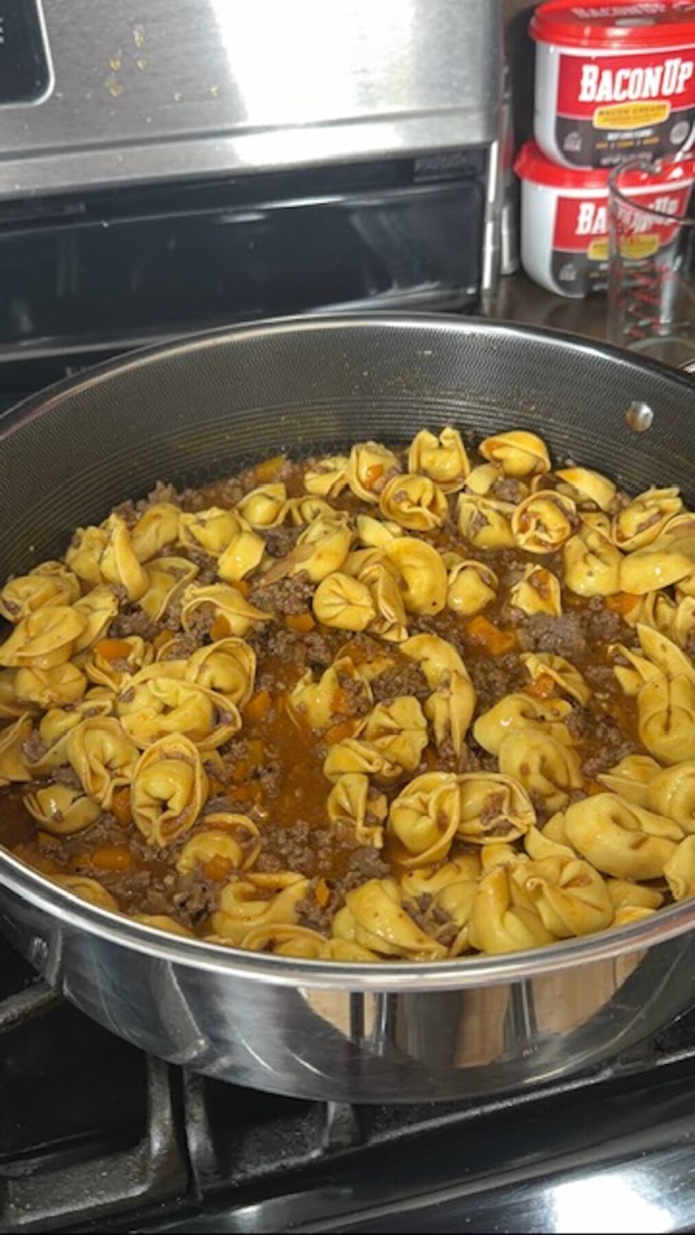 cooked sloppy joe tortellini in pan on stove, ready for cheese